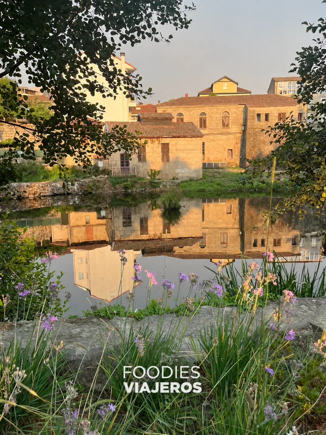A building next to the Arnoia River and its reflection